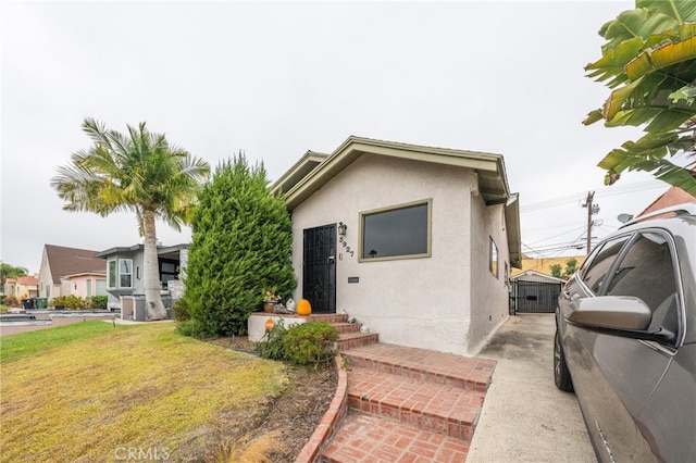 3927 W 58th Pl, Los Angeles, CA 90043 - view of front of home featuring stucco siding, a front lawn, and central AC