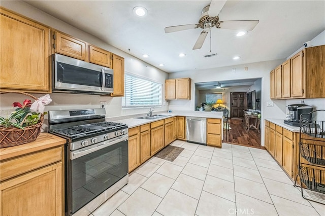 3927 W 58th Pl, Los Angeles, CA 90043 - kitchen with stainless steel appliances, a ceiling fan, light countertops, a peninsula, and a sink