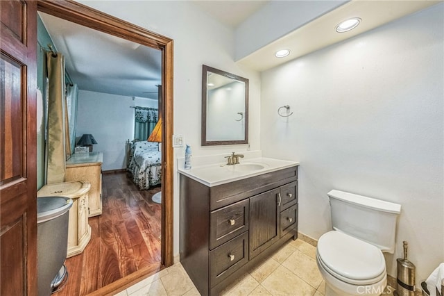 bathroom with wood-type flooring, vanity, and toilet