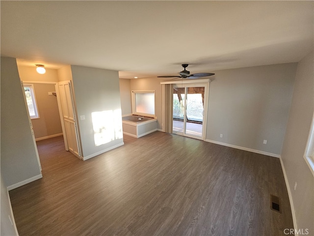 unfurnished living room with ceiling fan and dark wood-type flooring