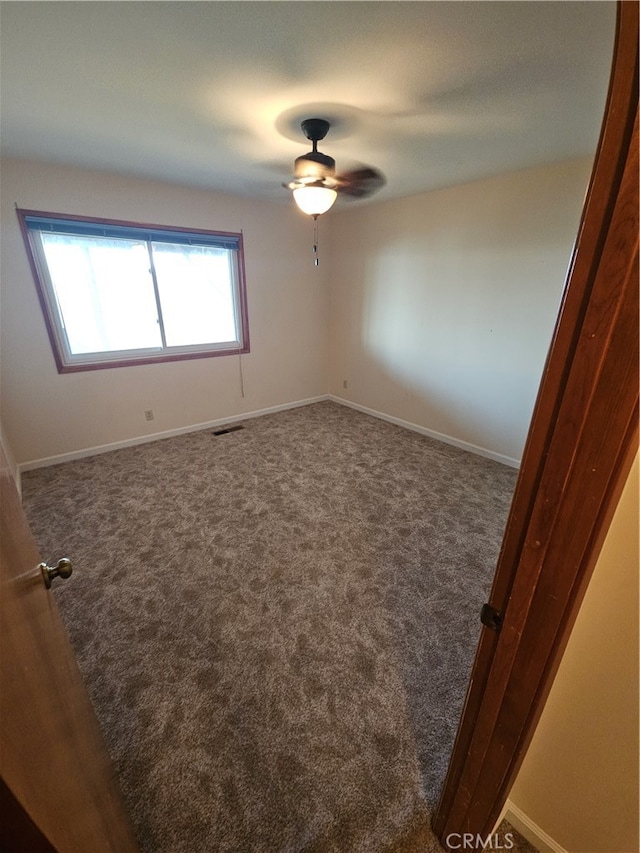 carpeted spare room with ceiling fan