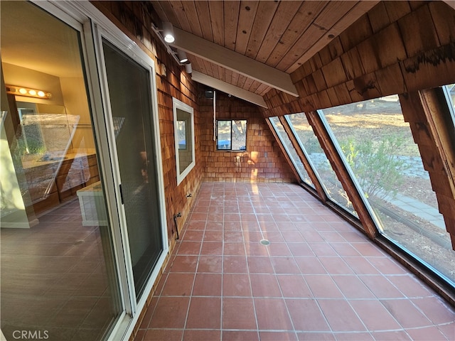 unfurnished sunroom featuring wood ceiling and lofted ceiling with beams