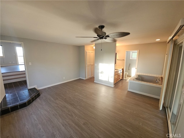 unfurnished living room with ceiling fan and dark hardwood / wood-style flooring