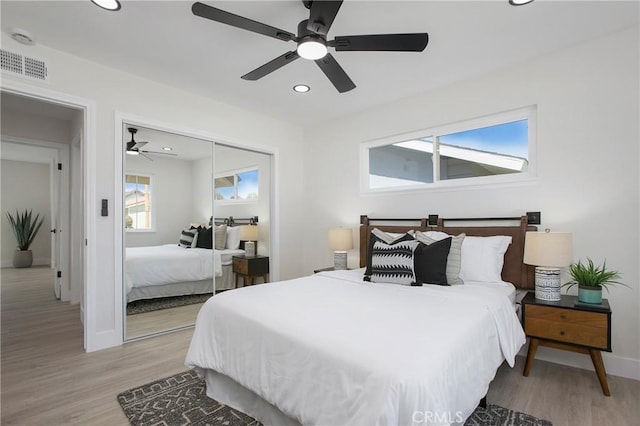 bedroom featuring light hardwood / wood-style floors, a closet, and ceiling fan