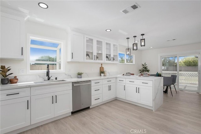 kitchen with white cabinetry, dishwasher, sink, light hardwood / wood-style floors, and decorative light fixtures