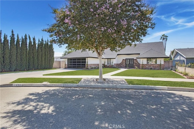 view of front of home with a front yard and a garage