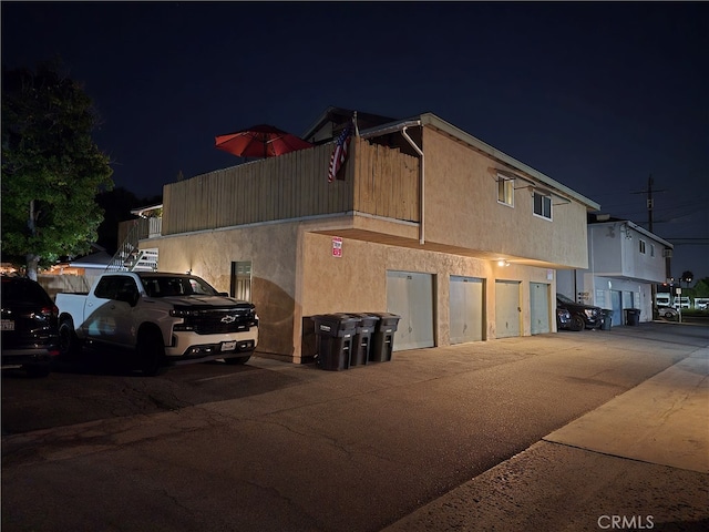 property exterior at night with a garage