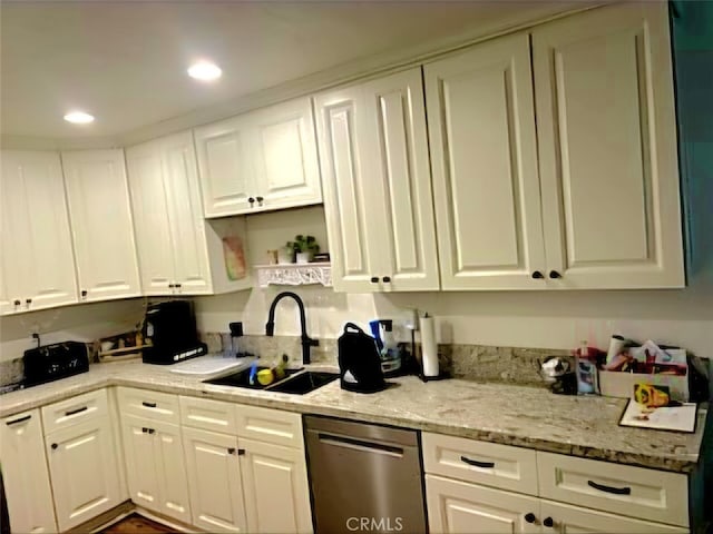 kitchen with white cabinets, dishwasher, light stone countertops, and sink