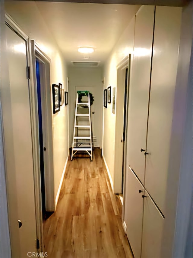 corridor with light hardwood / wood-style flooring