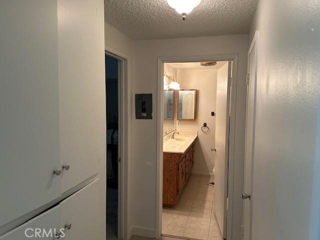 bathroom with tile patterned floors, vanity, and a textured ceiling