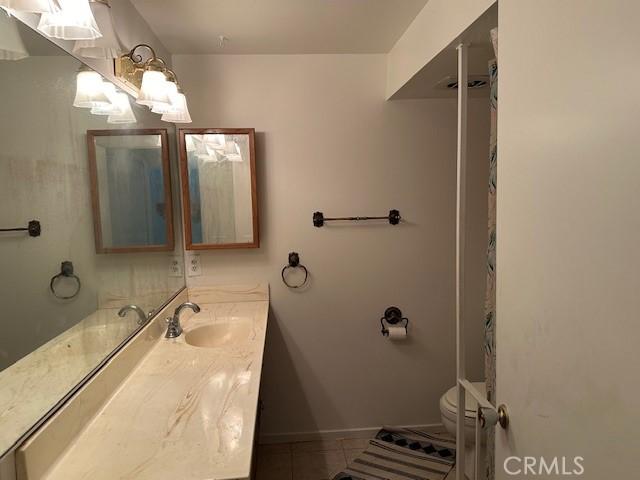 bathroom featuring tile patterned floors, vanity, and toilet