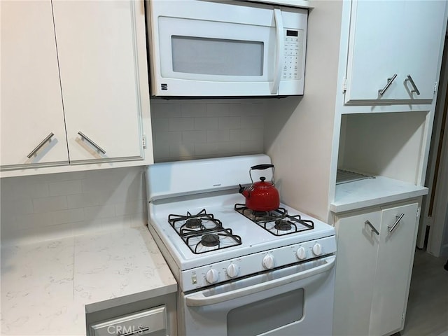 kitchen with white cabinets, white appliances, and tasteful backsplash