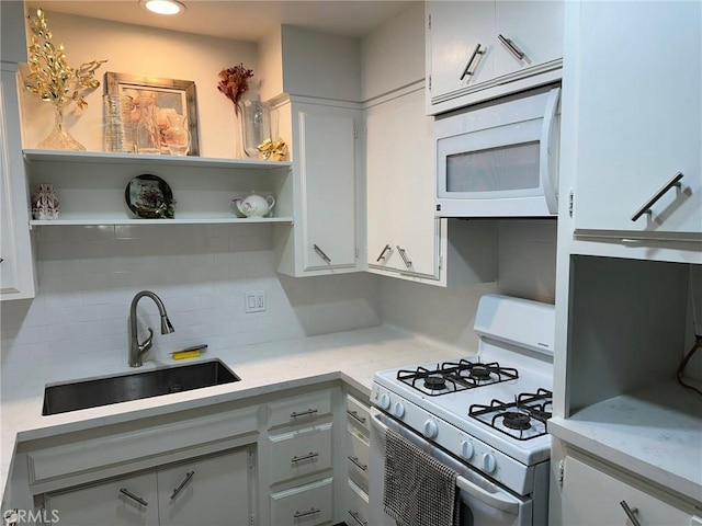 kitchen with white cabinetry, white appliances, sink, and tasteful backsplash