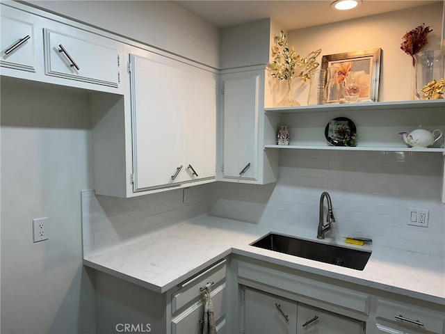 kitchen with white cabinets, tasteful backsplash, and sink