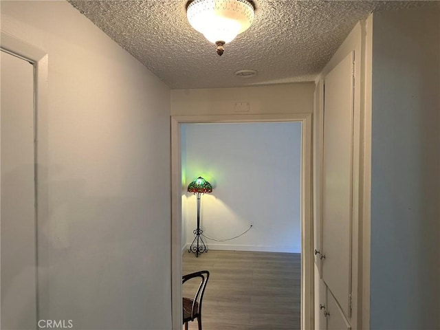 hall featuring hardwood / wood-style floors and a textured ceiling