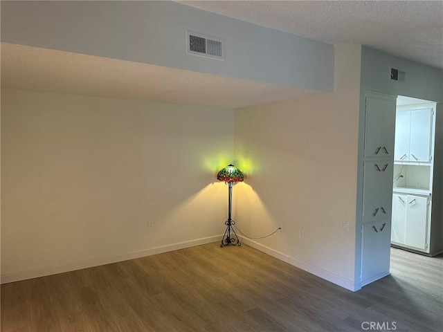 spare room with wood-type flooring and a textured ceiling