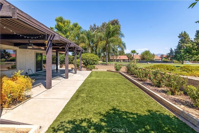 view of yard with ceiling fan and a patio