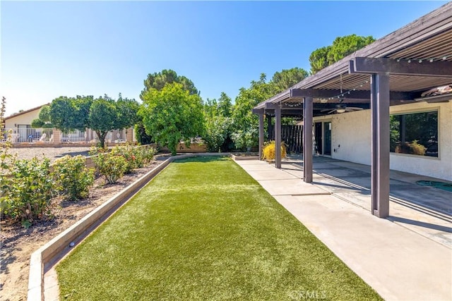 view of yard with ceiling fan, a patio area, and a pergola