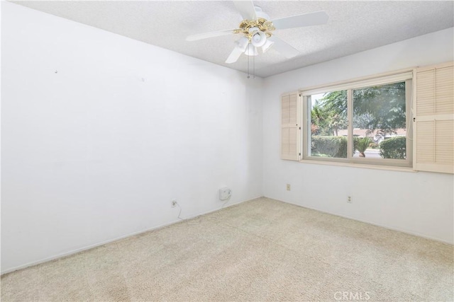 carpeted empty room with ceiling fan and a textured ceiling