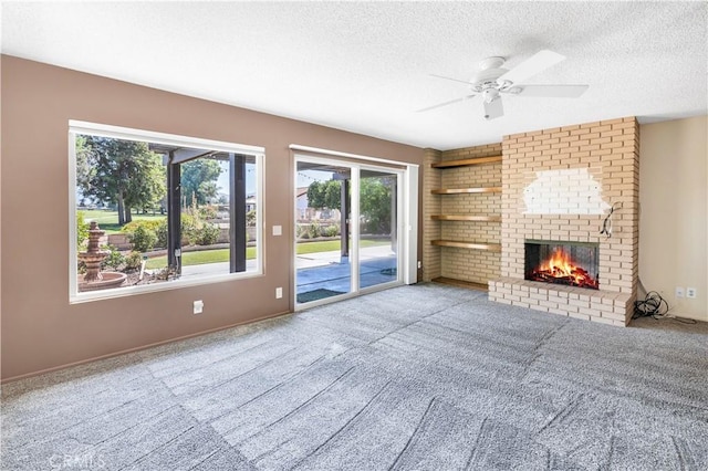 unfurnished living room with ceiling fan, a fireplace, carpet, and a textured ceiling