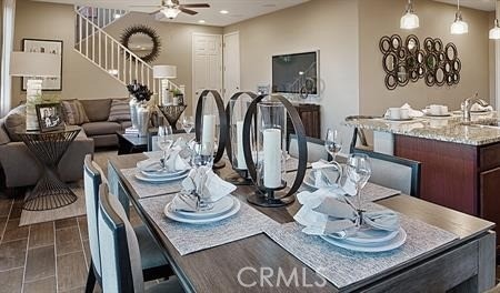 tiled dining space featuring ceiling fan and sink