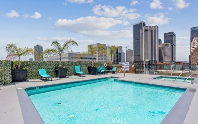 view of swimming pool featuring a community hot tub and a patio