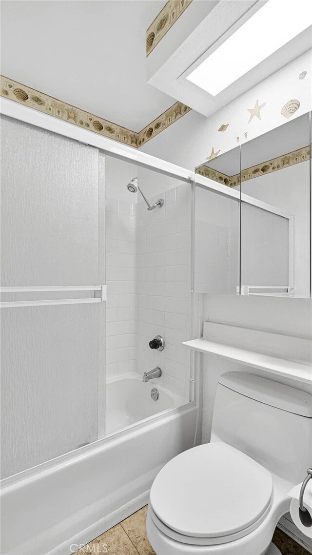 bathroom with tile patterned floors, tiled shower / bath, and toilet