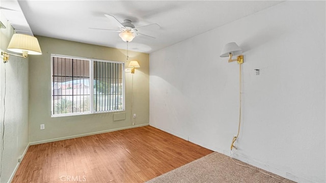empty room with baseboards, a ceiling fan, and wood finished floors