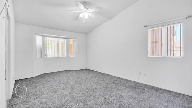 carpeted spare room featuring lofted ceiling and ceiling fan