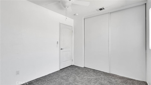 unfurnished bedroom featuring ceiling fan, carpet flooring, visible vents, and a closet