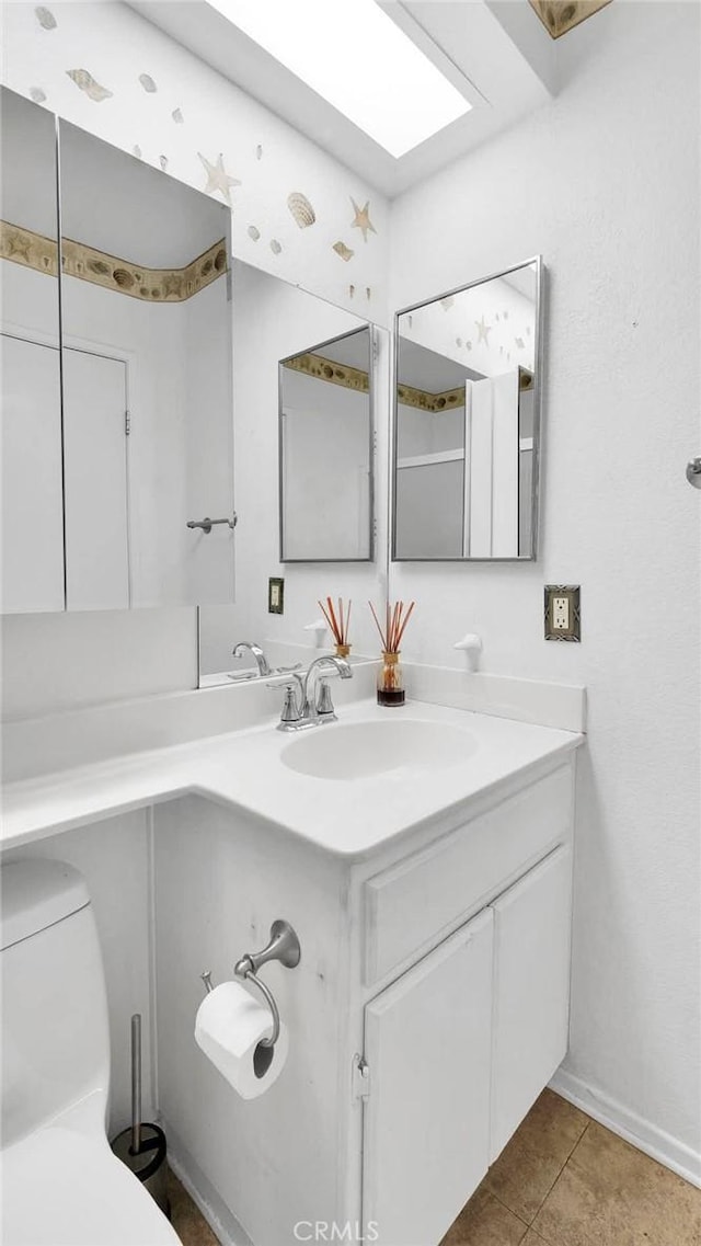 bathroom featuring tile patterned flooring, toilet, and vanity