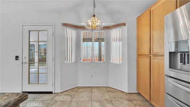 unfurnished dining area with baseboards, a wealth of natural light, a chandelier, and light tile patterned floors