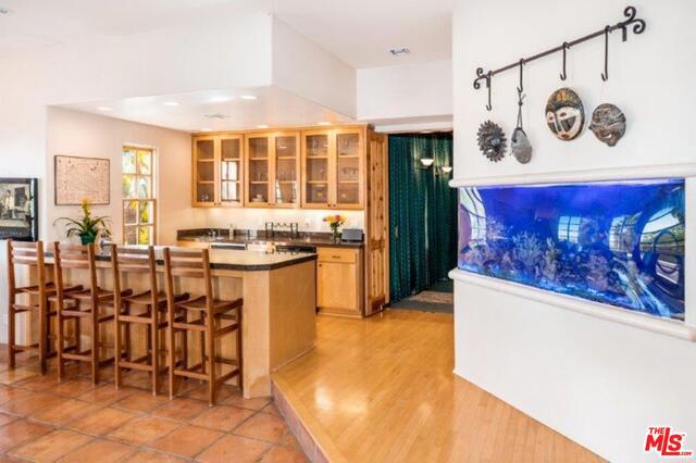 kitchen with a kitchen bar, kitchen peninsula, and light hardwood / wood-style flooring