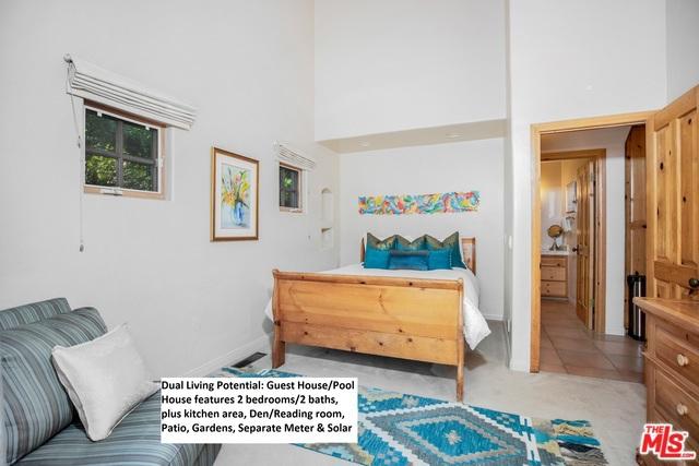 bedroom featuring light carpet and a towering ceiling