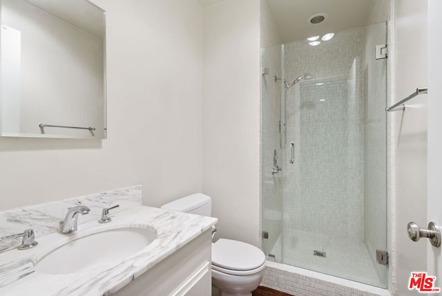 bathroom with vanity, a shower with shower door, and toilet