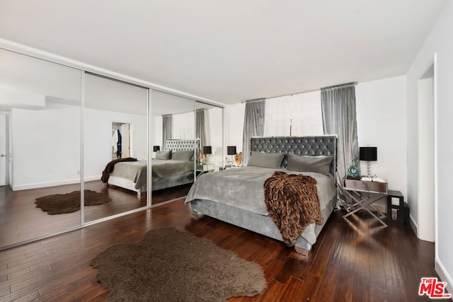 bedroom with dark wood-type flooring and a closet