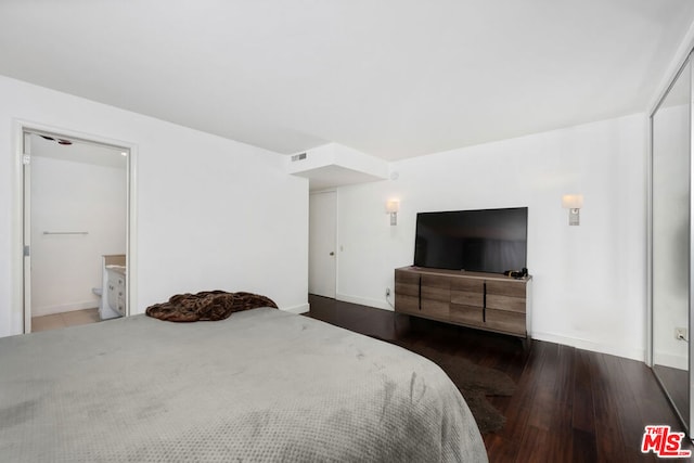 bedroom featuring dark hardwood / wood-style floors and ensuite bathroom