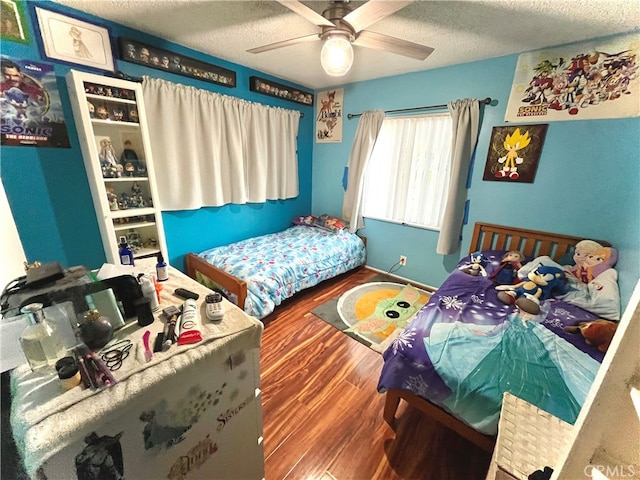 bedroom with ceiling fan, a textured ceiling, and hardwood / wood-style floors