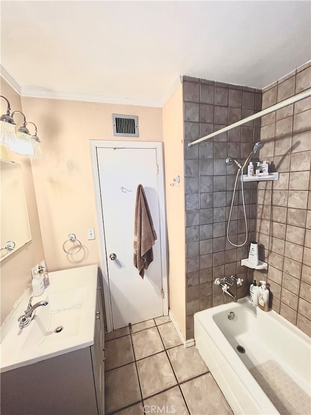 bathroom with ornamental molding, tile patterned flooring, tiled shower / bath, and vanity