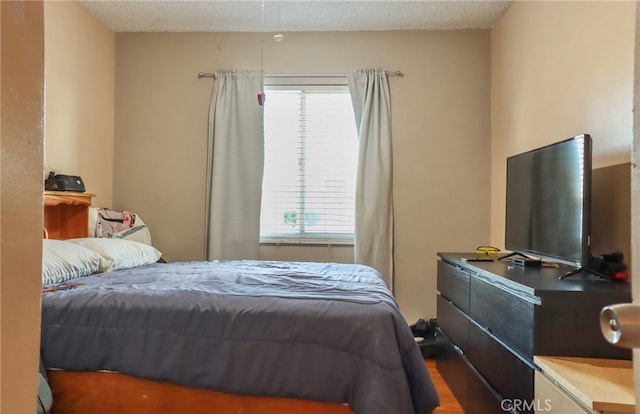 bedroom featuring a textured ceiling and hardwood / wood-style flooring