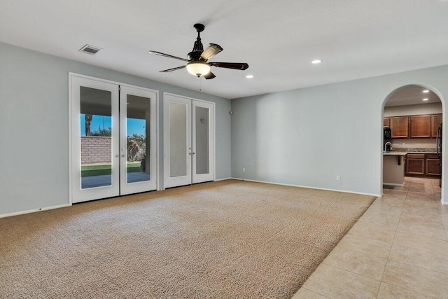 empty room with ceiling fan, light carpet, and french doors