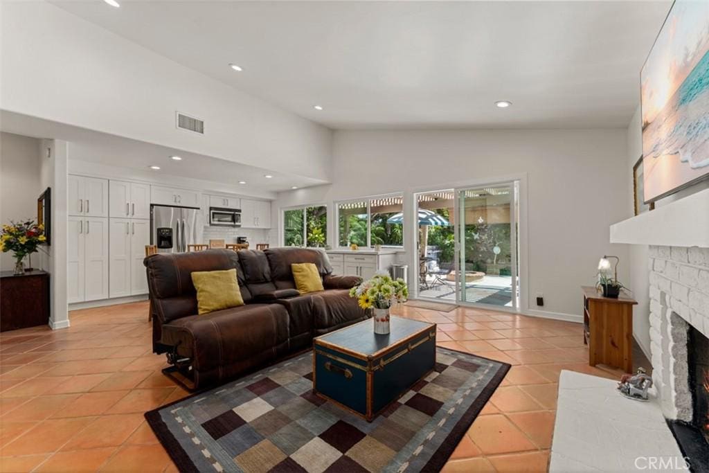 living room featuring light tile patterned floors and high vaulted ceiling