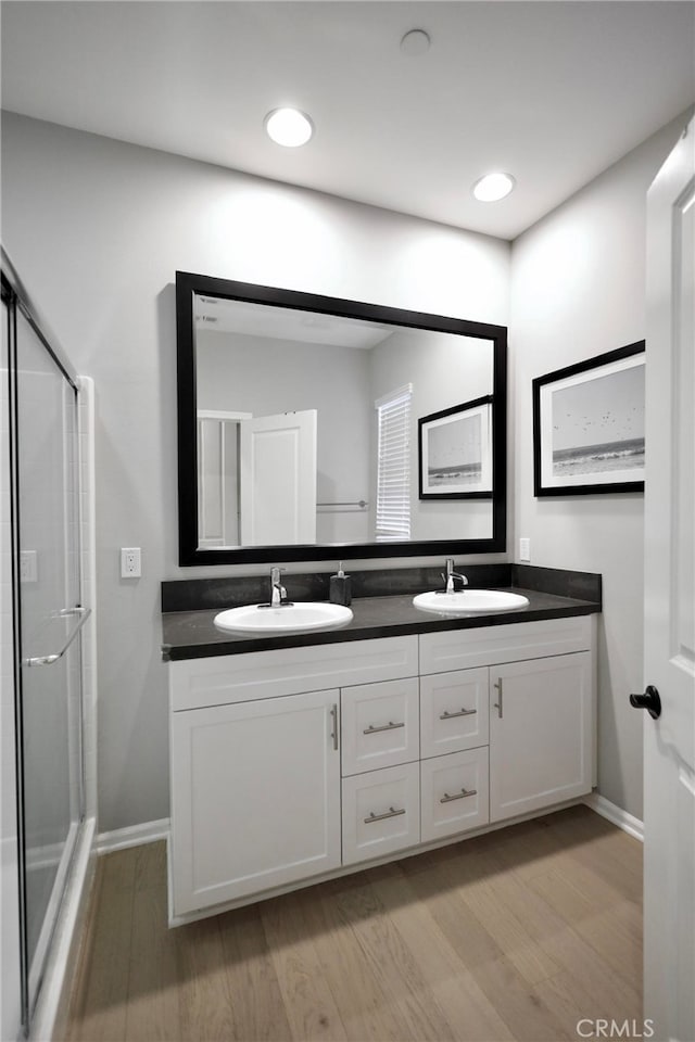 bathroom featuring wood-type flooring, vanity, and an enclosed shower