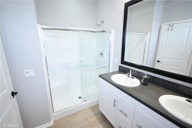 bathroom with wood-type flooring, vanity, and an enclosed shower