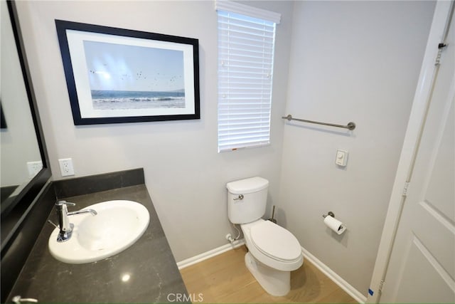 bathroom with hardwood / wood-style floors, vanity, and toilet