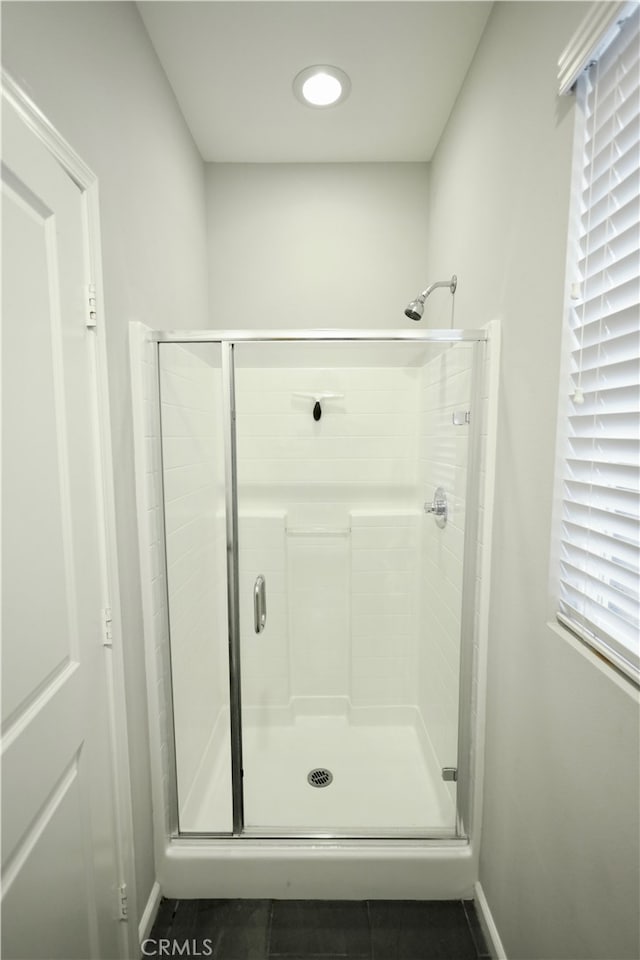 bathroom with tile patterned flooring and a shower with door