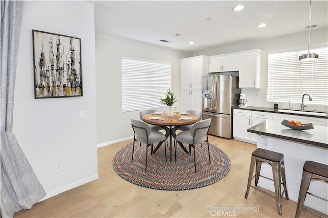 dining room with sink and light hardwood / wood-style flooring