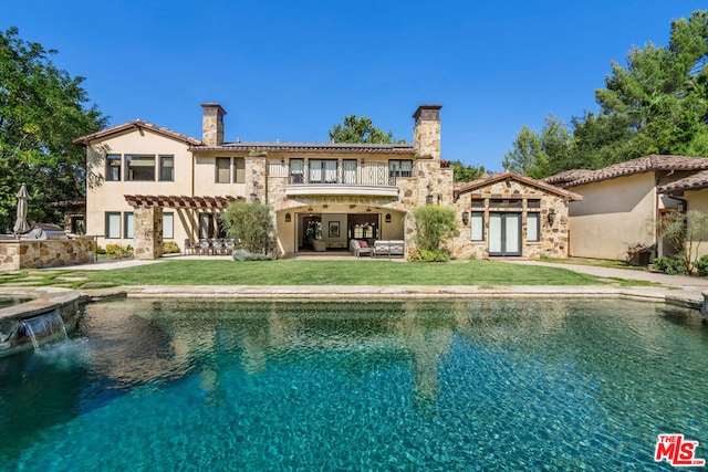 back of property featuring pool water feature, a patio area, and a yard