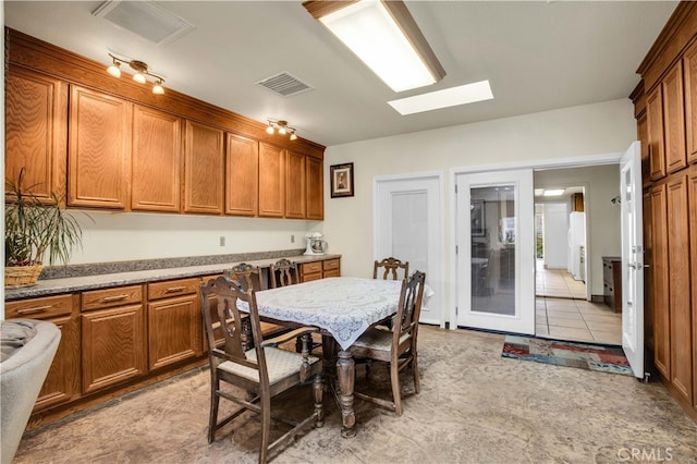 tiled dining room featuring a skylight