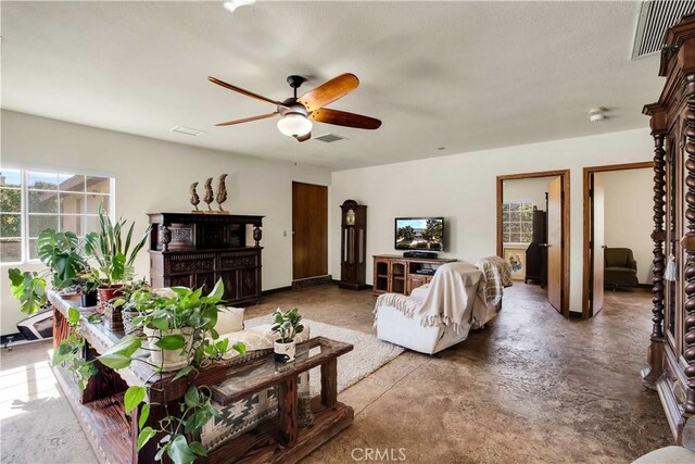 living room featuring a textured ceiling and ceiling fan